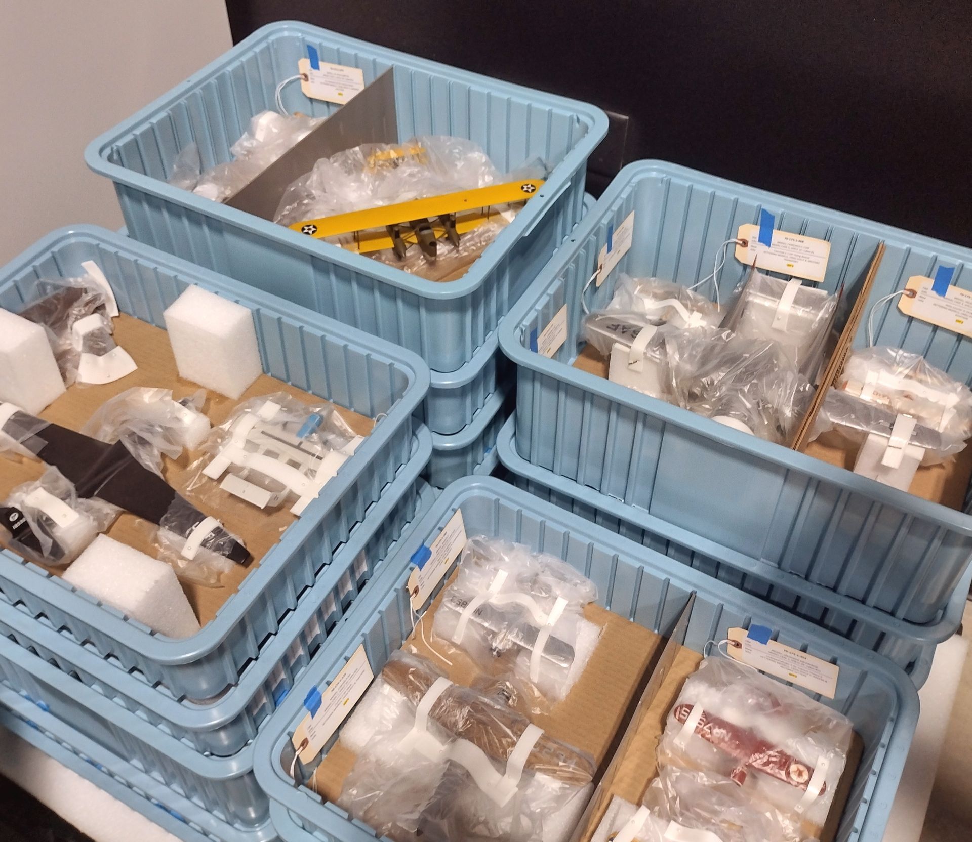 A stack of blue plastic bins filled with various items