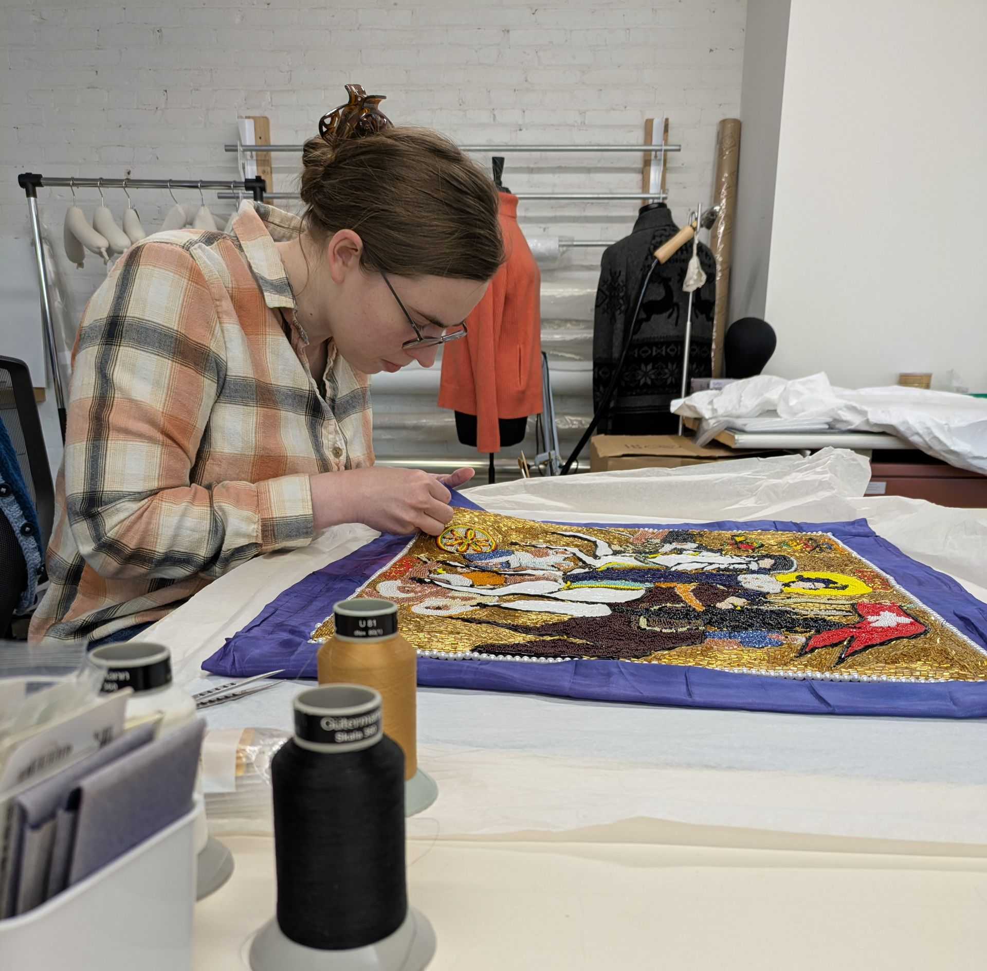 A woman wearing purple gloves is working on a red object