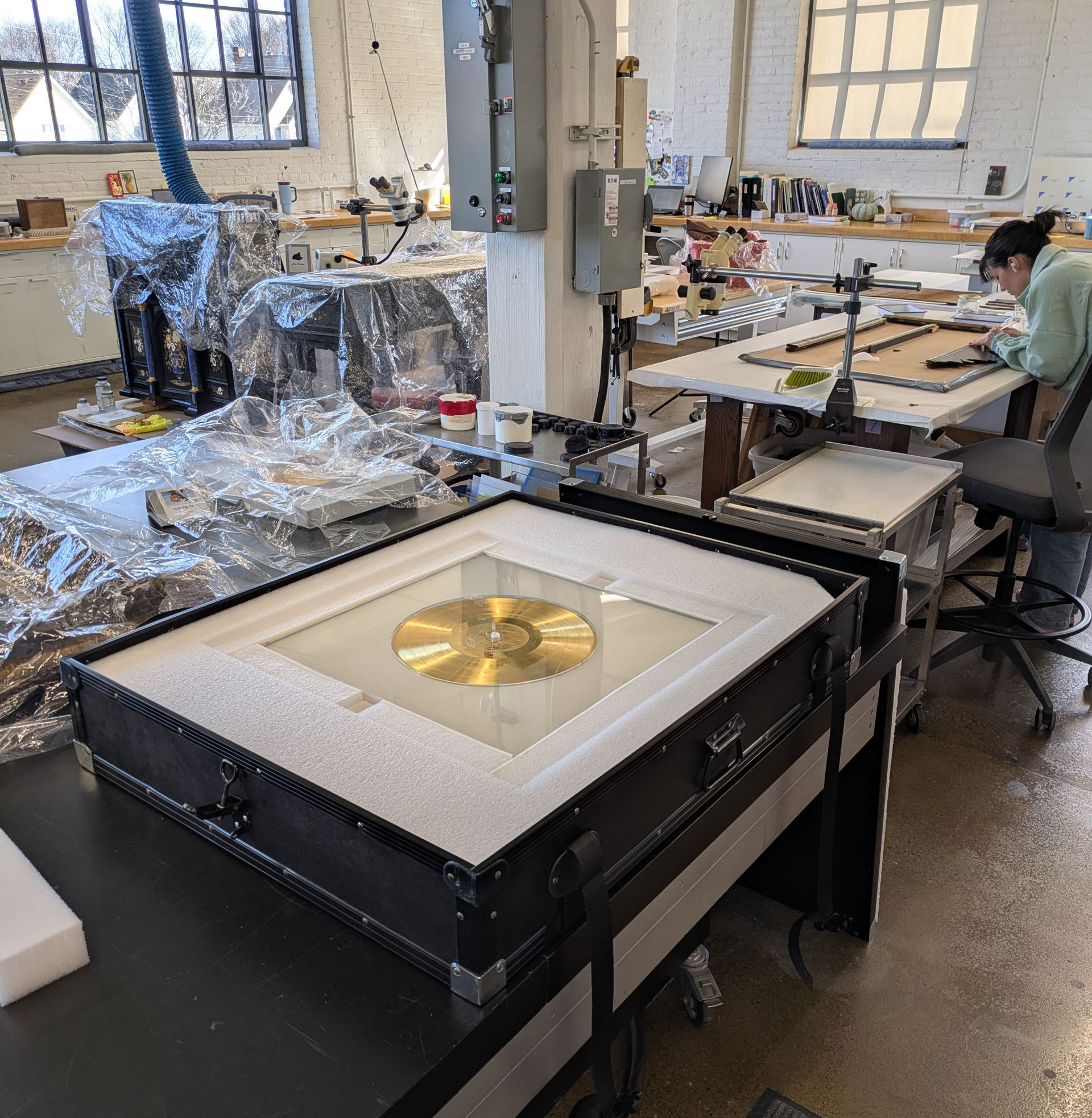 A man is painting a picture on an easel in a studio.