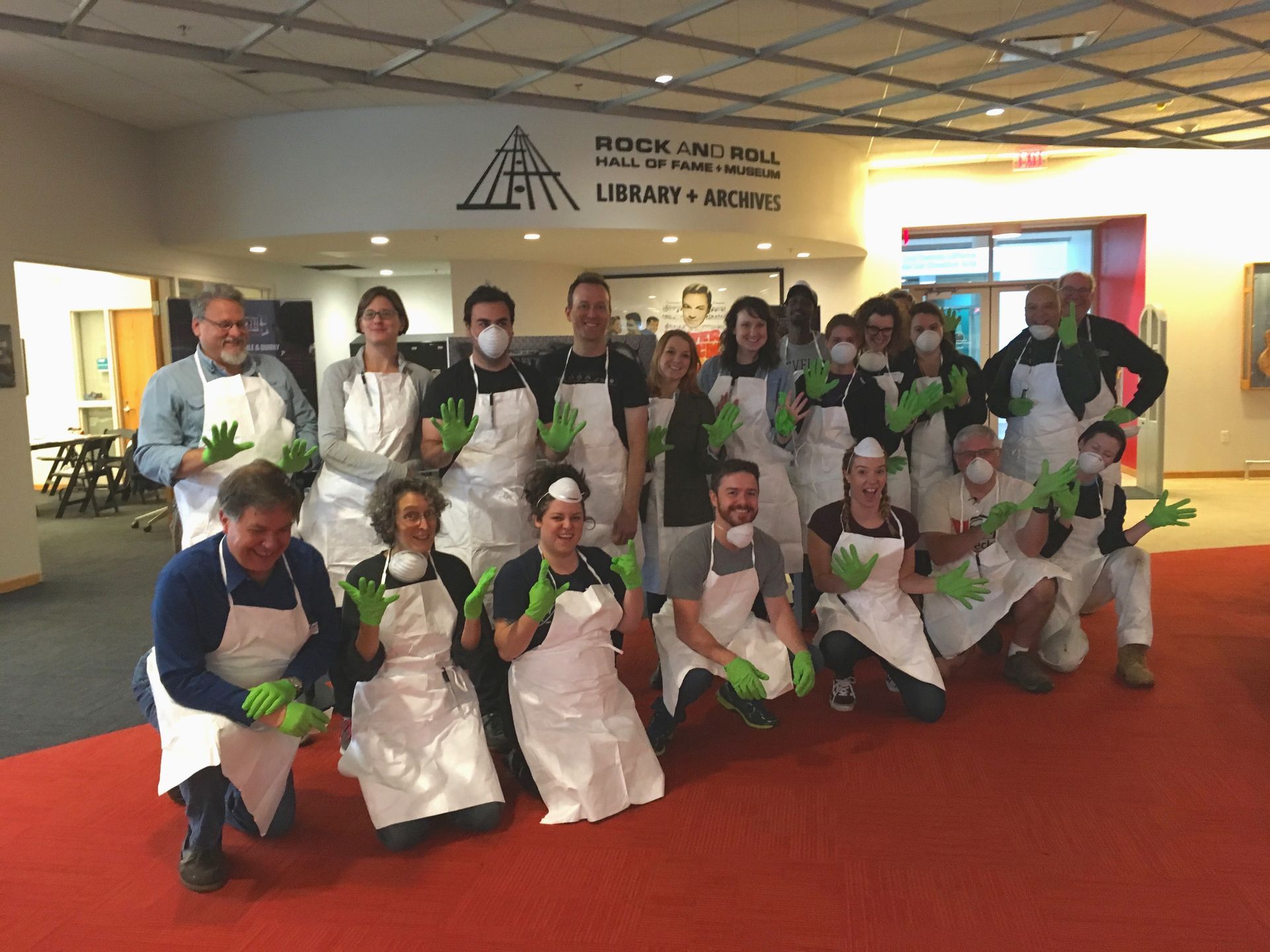 A group of people wearing aprons and gloves are posing for a picture.