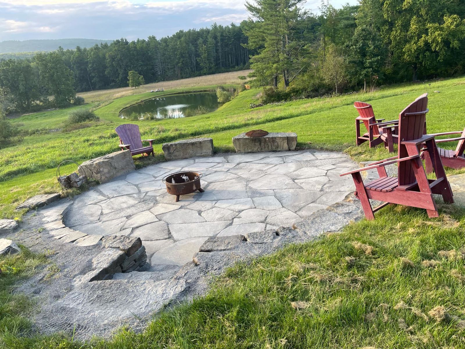 A fire pit in the middle of a lush green field