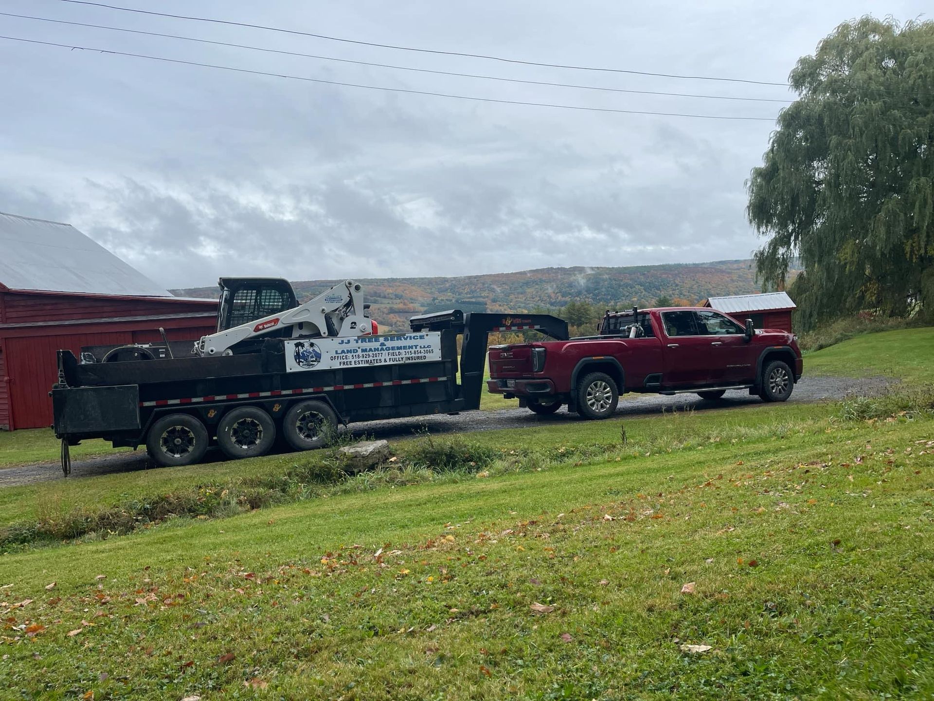 A red truck is pulling a trailer with a bulldozer on it