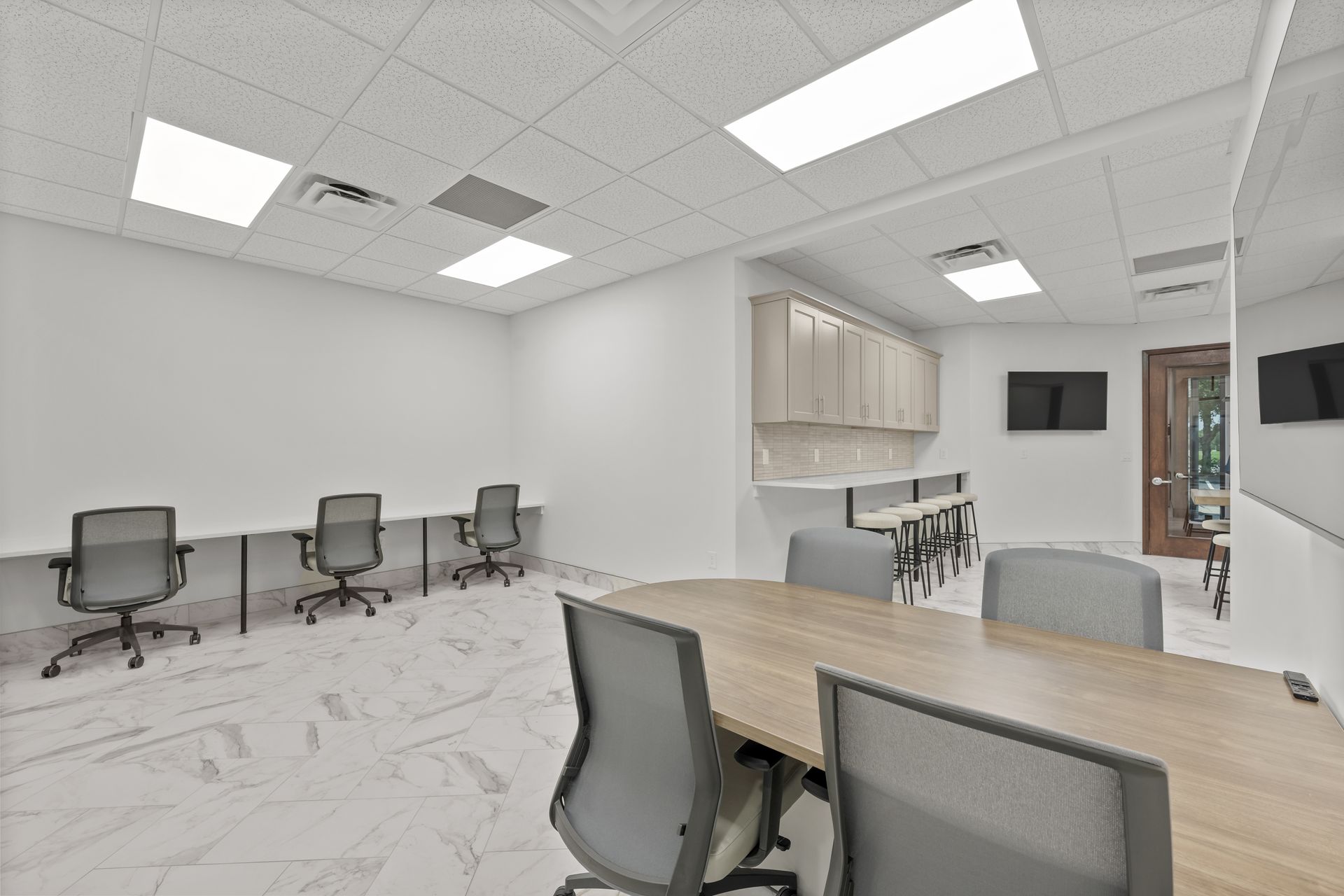 A room with a long table and chairs in it.