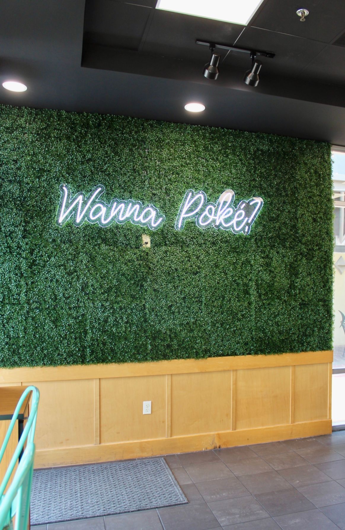 There is a neon sign on the wall that says `` wanna poke ? ''.