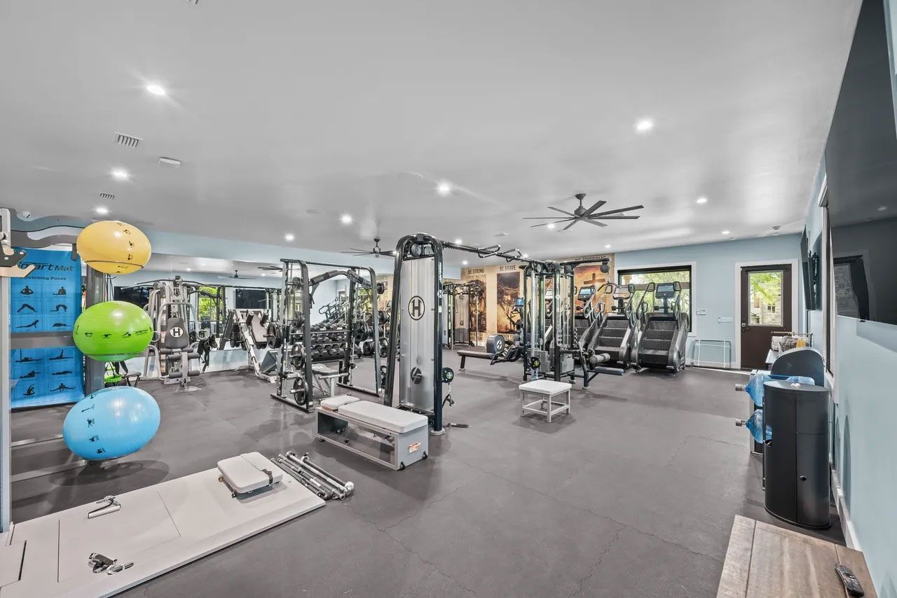 A large gym filled with lots of exercise equipment.
