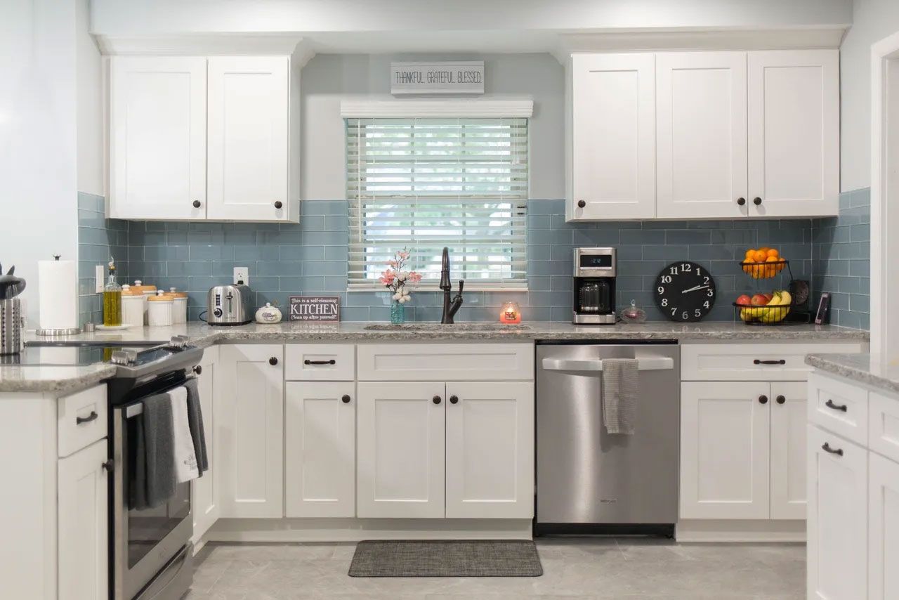A kitchen with white cabinets and stainless steel appliances.