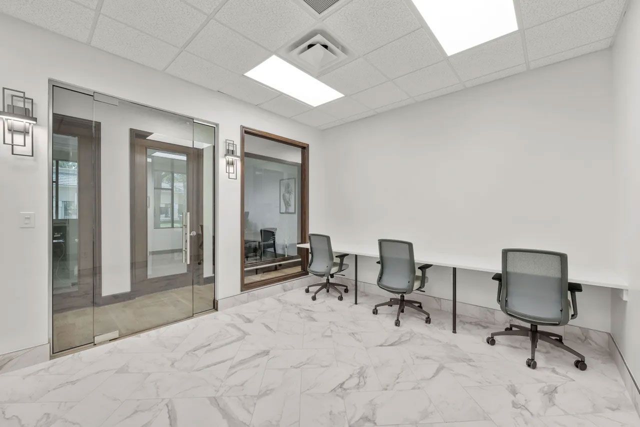 A room with three desks and chairs in it