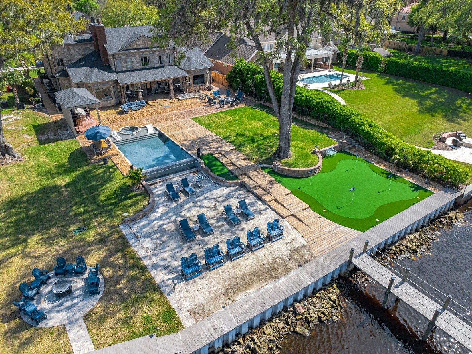 An aerial view of a large house with a swimming pool and a putting green.
