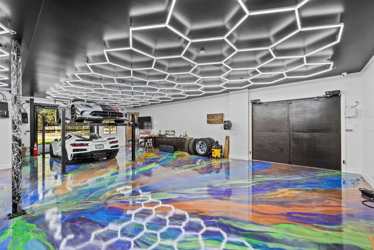 A car is parked in a garage with a colorful floor.