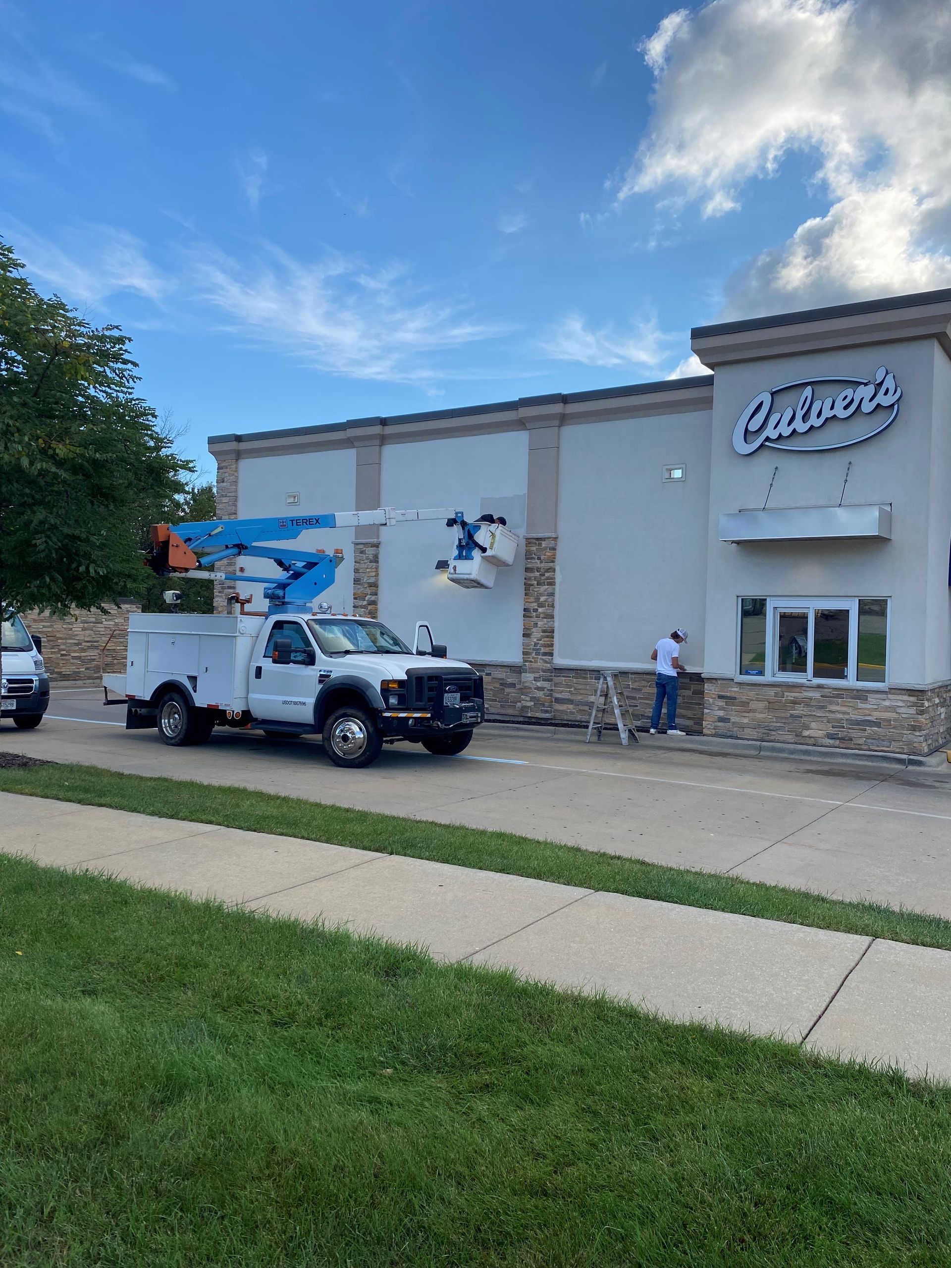 A white truck is parked in front of a store called calderon 's