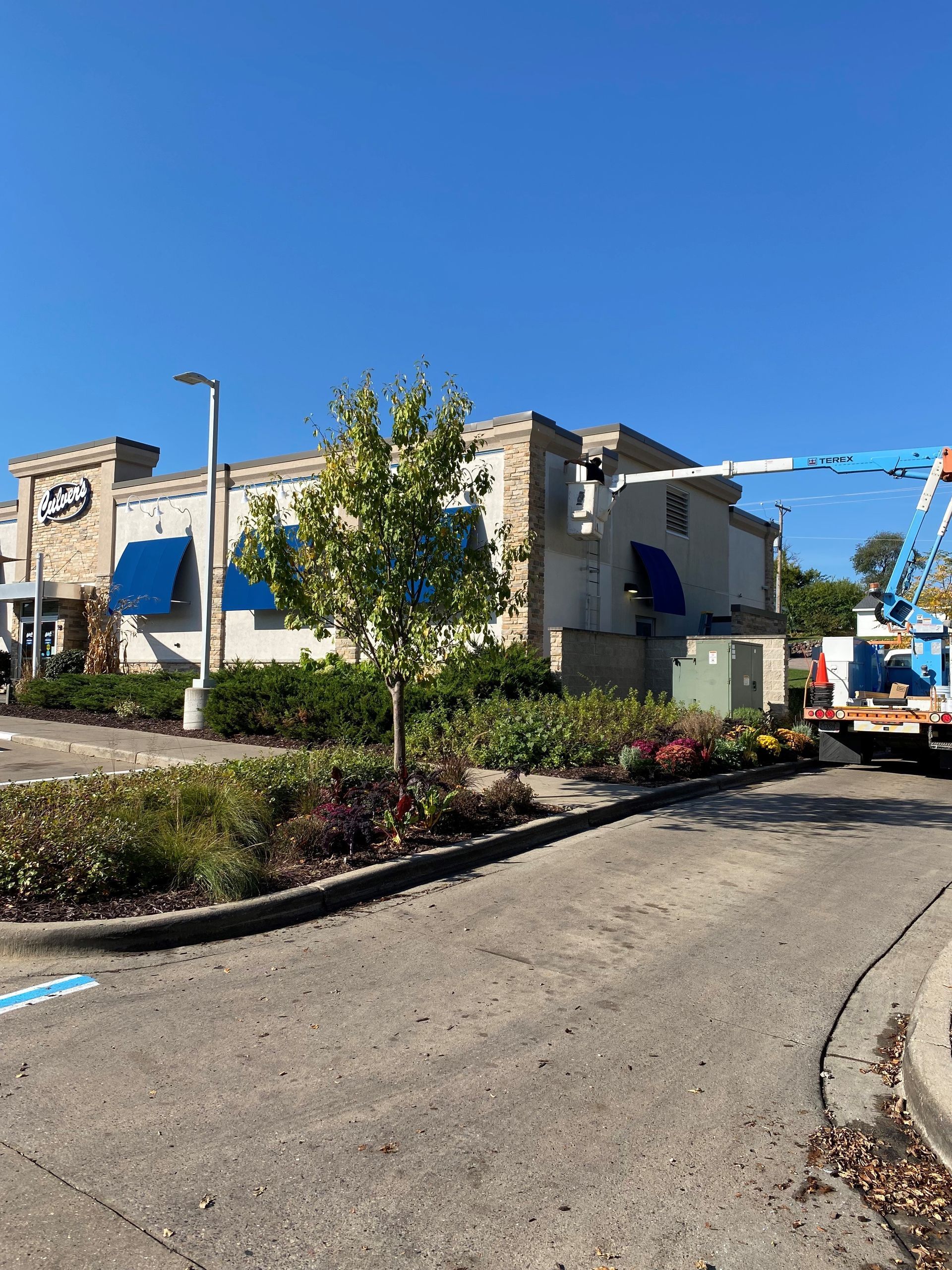 A truck is parked in front of a building with blue awnings
