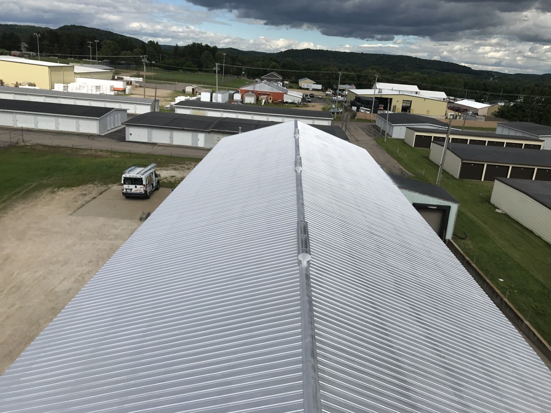 An aerial view of a large building with a white van parked in front of it.
