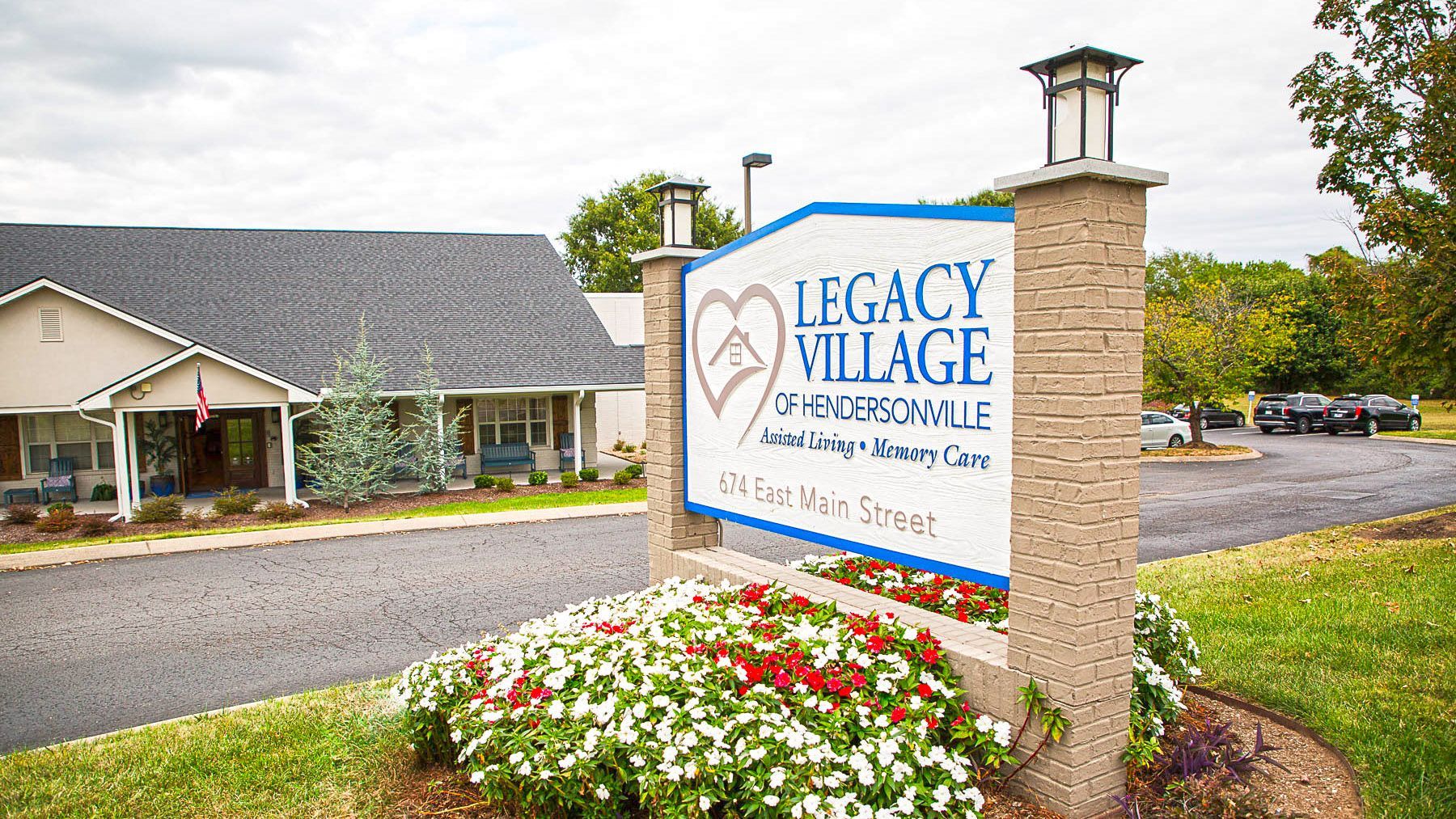 A sign for legacy village is in front of a building.
