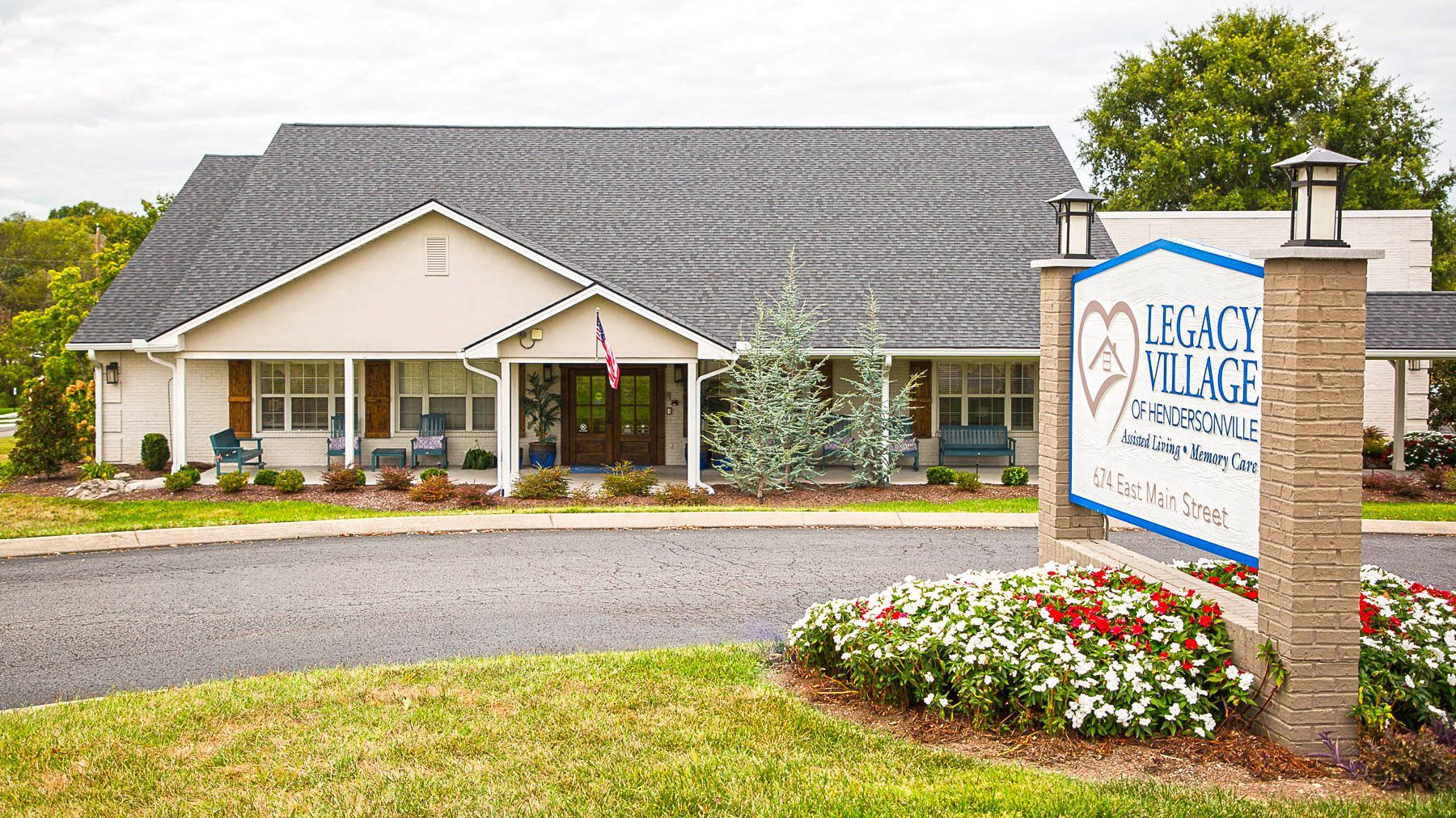 A white house with a sign in front of it that says legacy village