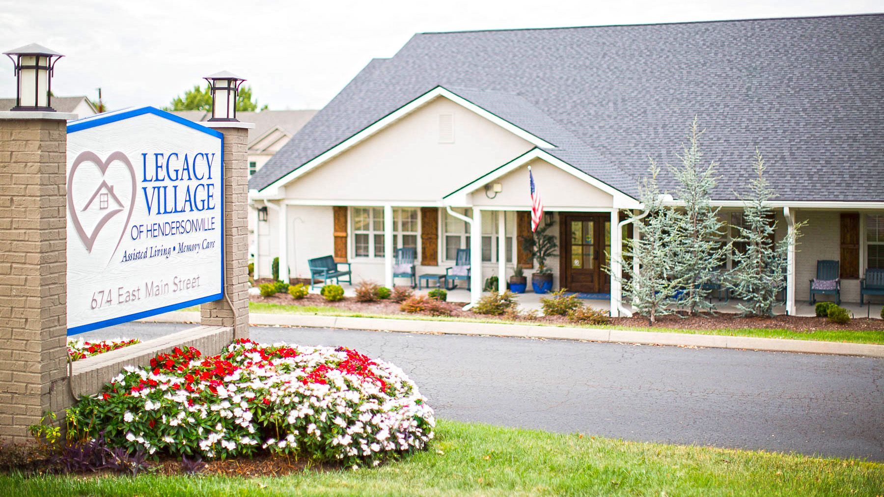 A white house with a sign that says legacy village