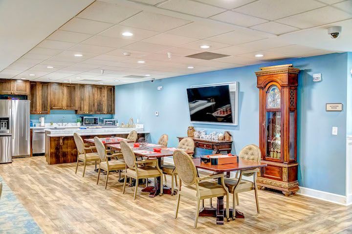 A large dining room with tables and chairs and a large grandfather clock.