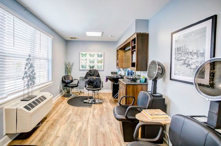 A hair salon with a lot of chairs and a window.
