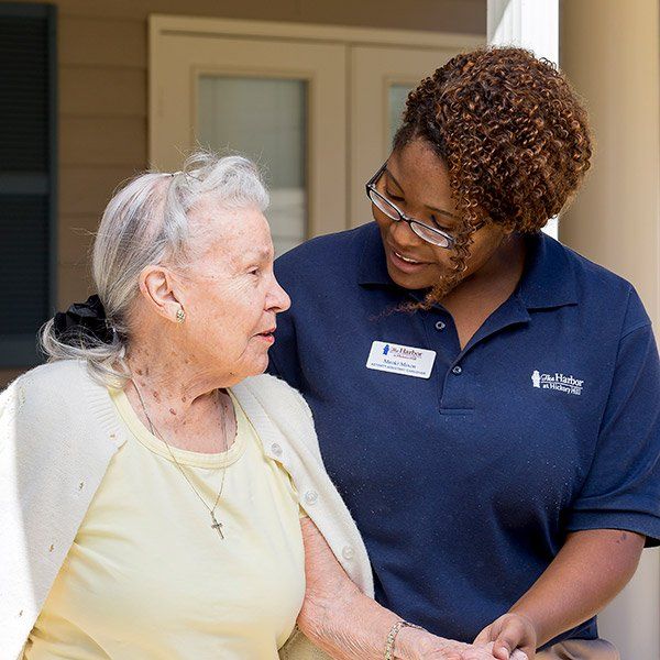 A woman in a blue shirt with a name tag on it is talking to an older woman