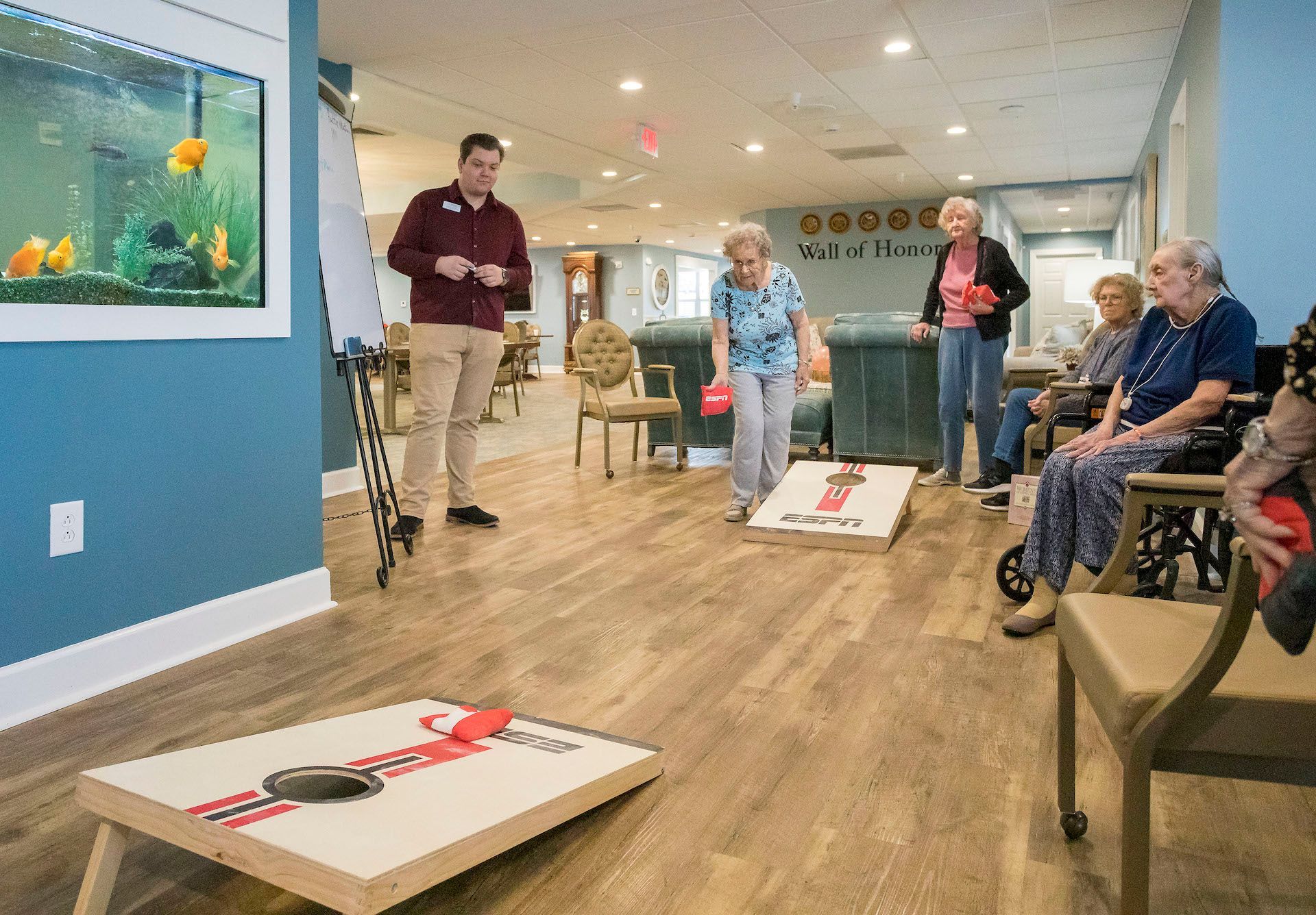 A group of people are playing a game of cornhole in a living room.