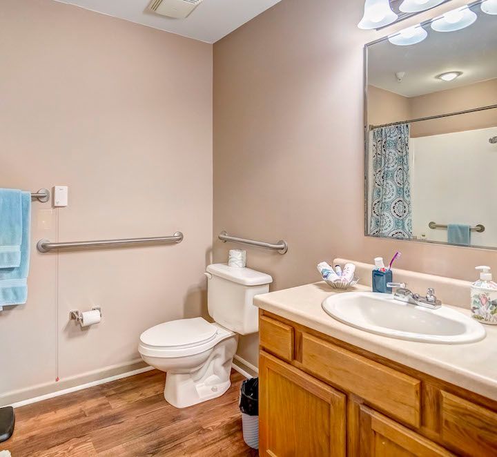 A bathroom with a toilet , sink and mirror