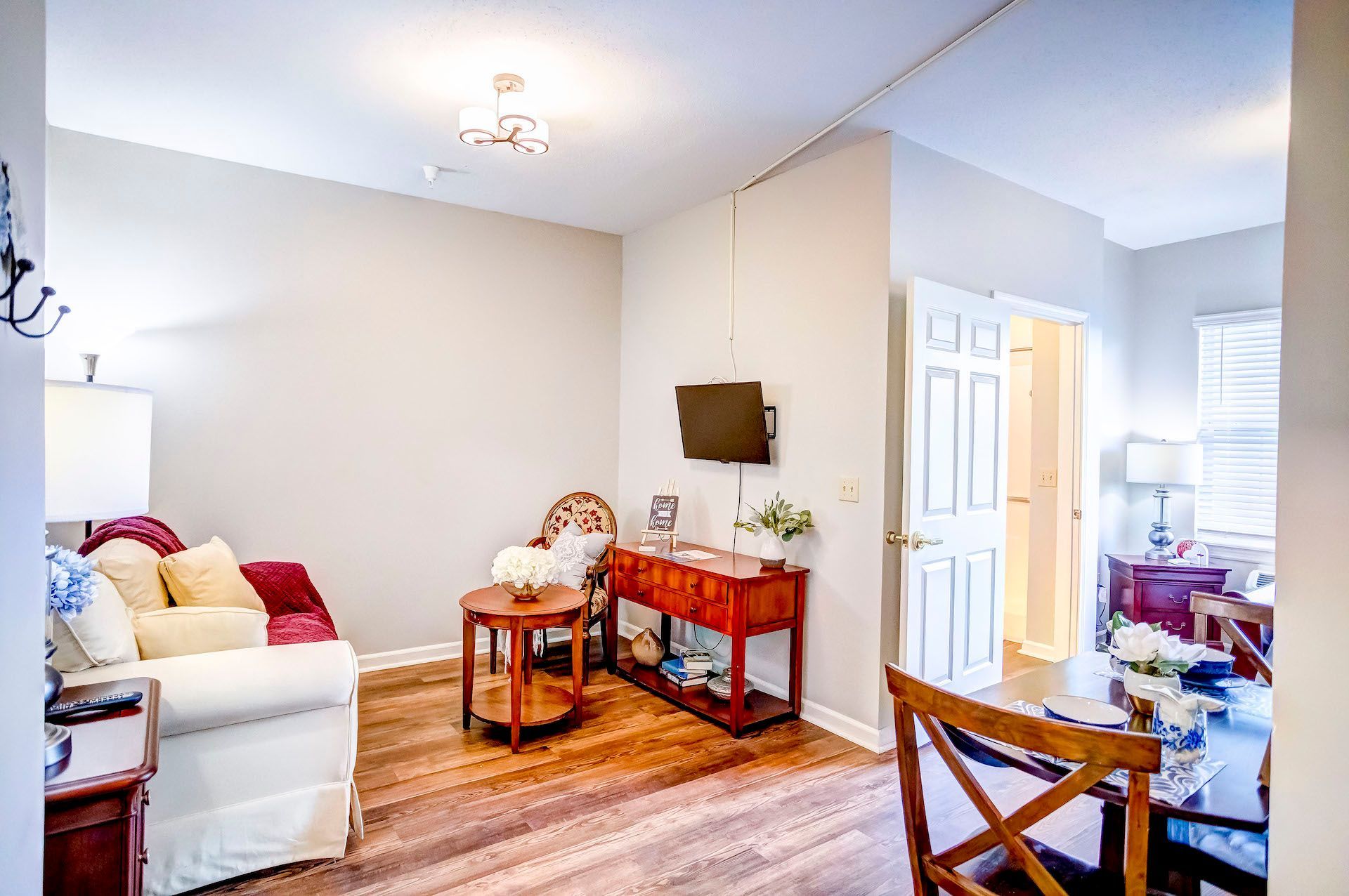 A living room with a couch , chair , table and television.