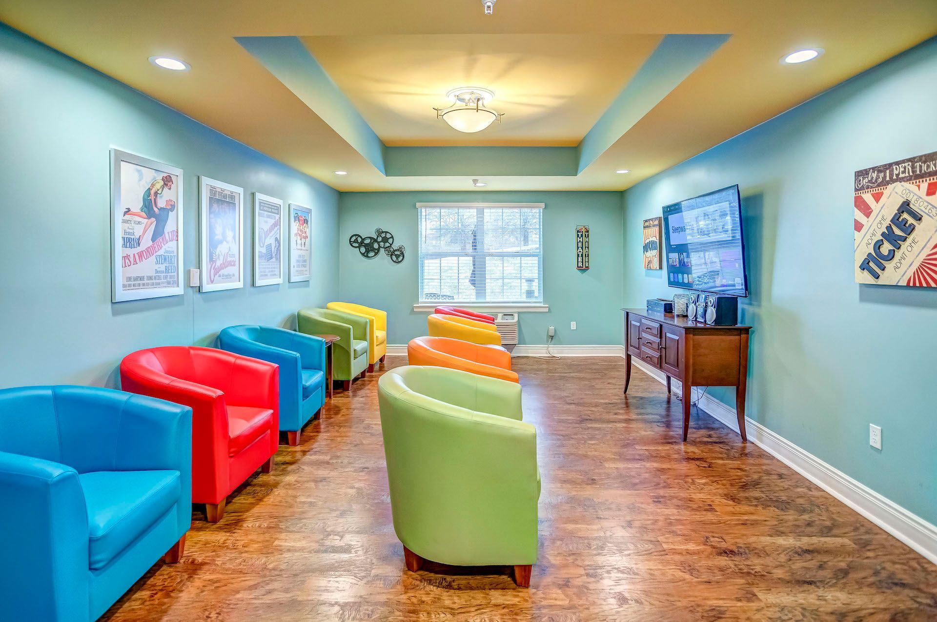 A living room with a lot of colorful chairs and a television.