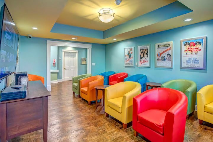 There are many colorful chairs in the room.