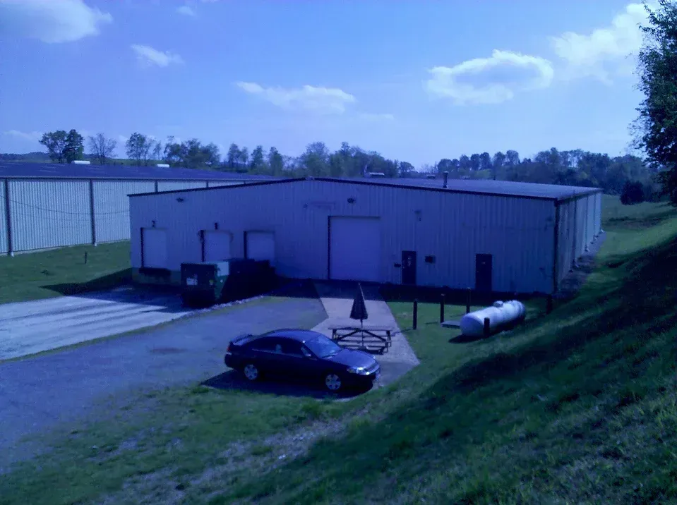 A car is parked in front of a large building