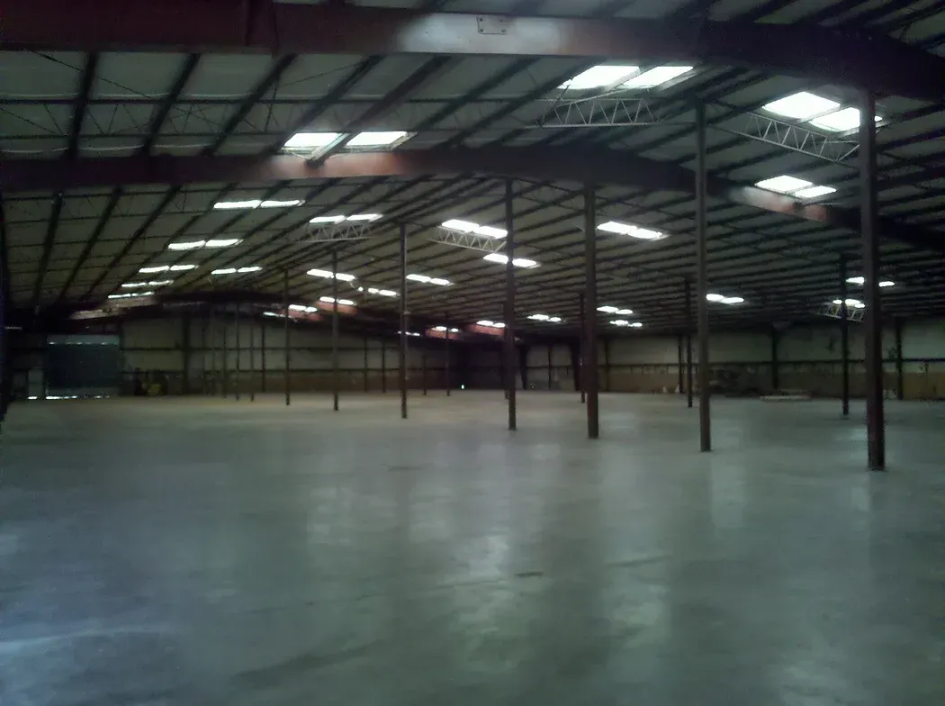 An empty warehouse with lots of lights on the ceiling