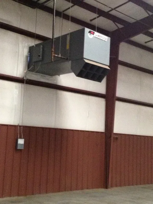 A large air conditioner is hanging from the ceiling of a building