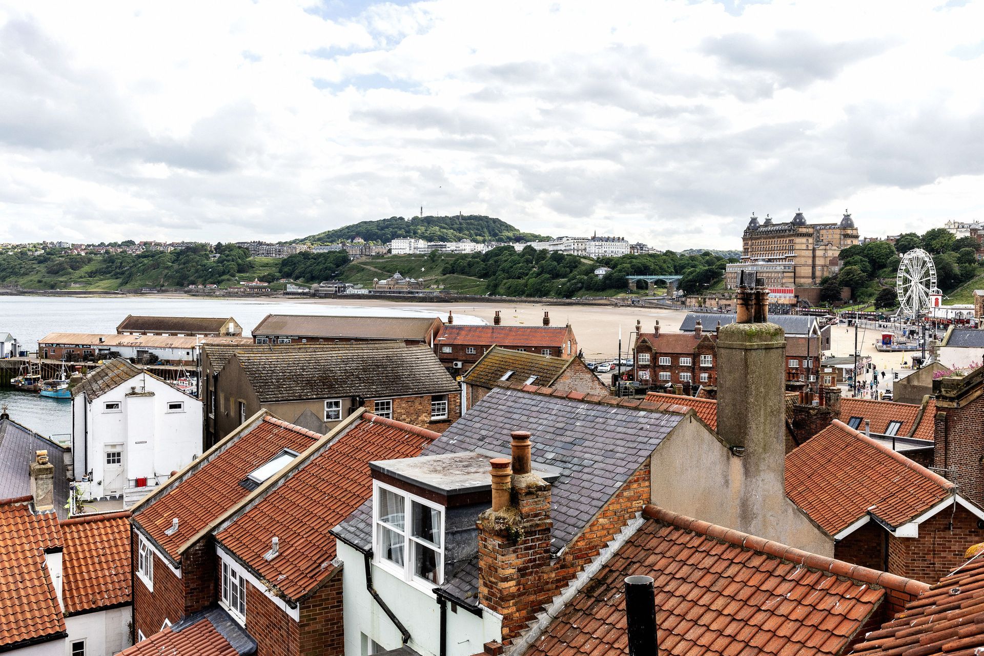 An aerial view of a city with a ferris wheel in the background.