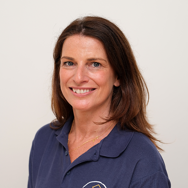 A woman in a blue shirt is smiling for the camera