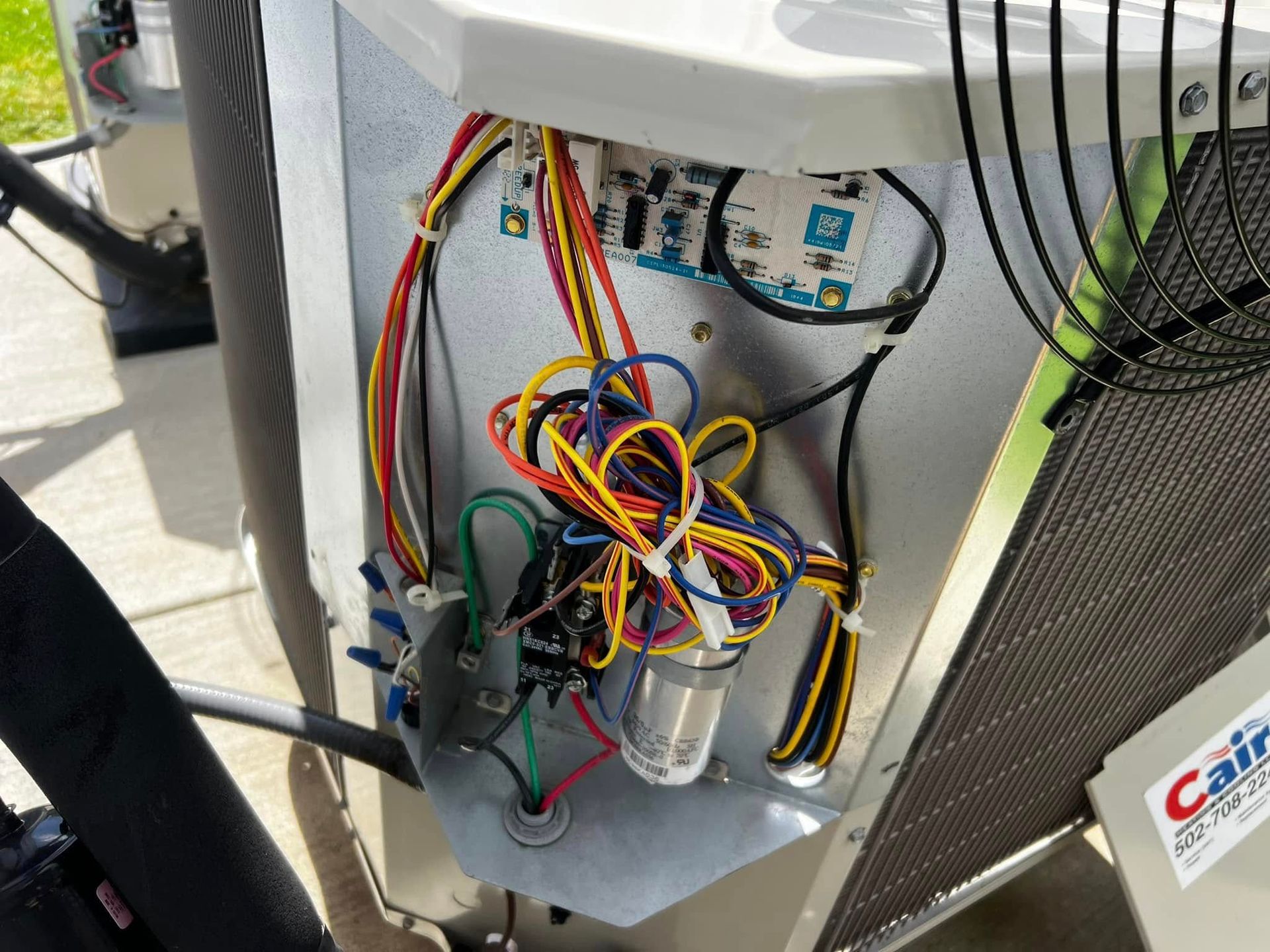 Open panel of an air conditioning unit showing wiring and electrical components.