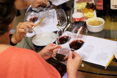 A group of people are sitting at a table holding wine glasses.