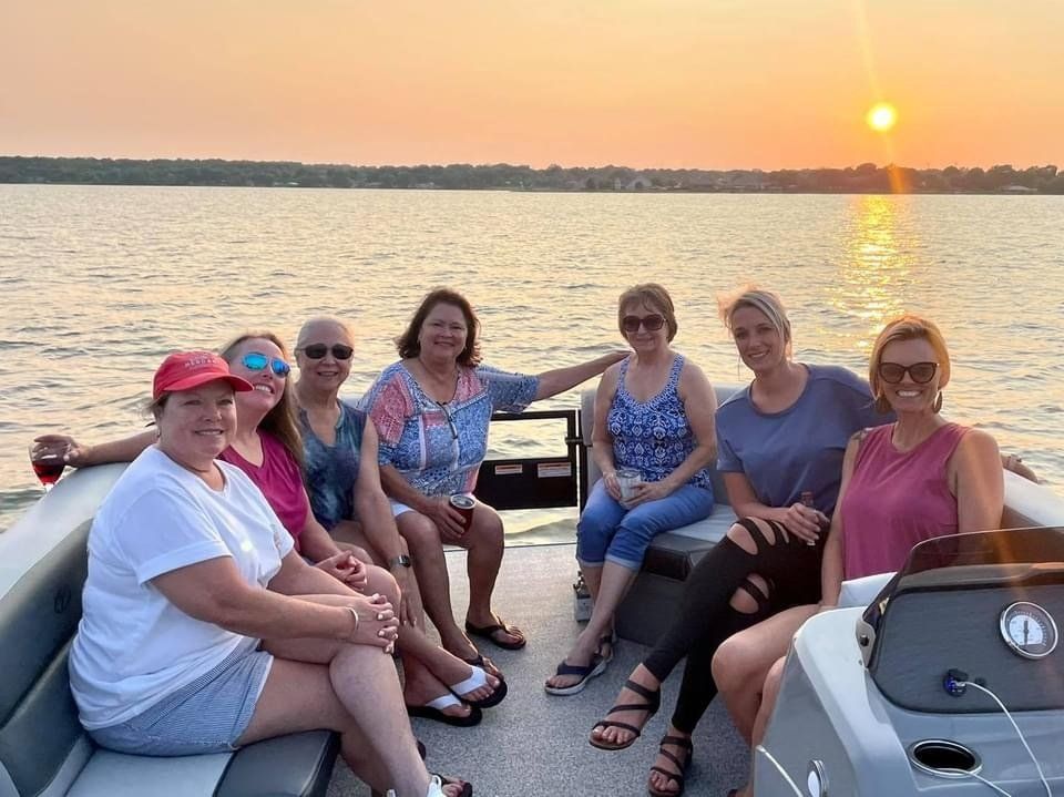 A group of women are sitting on the back of a boat.