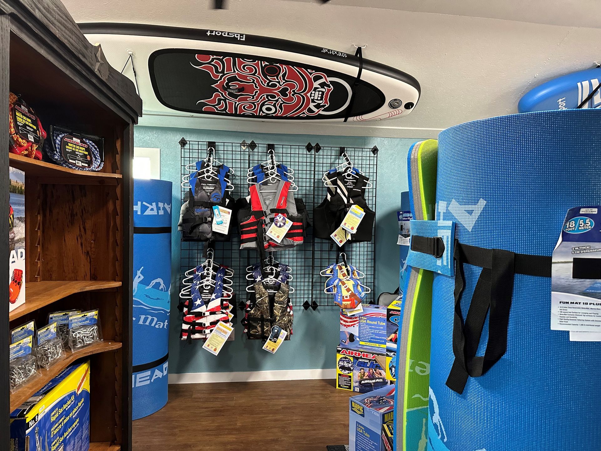 A store filled with lots of toys and a surfboard hanging from the ceiling.