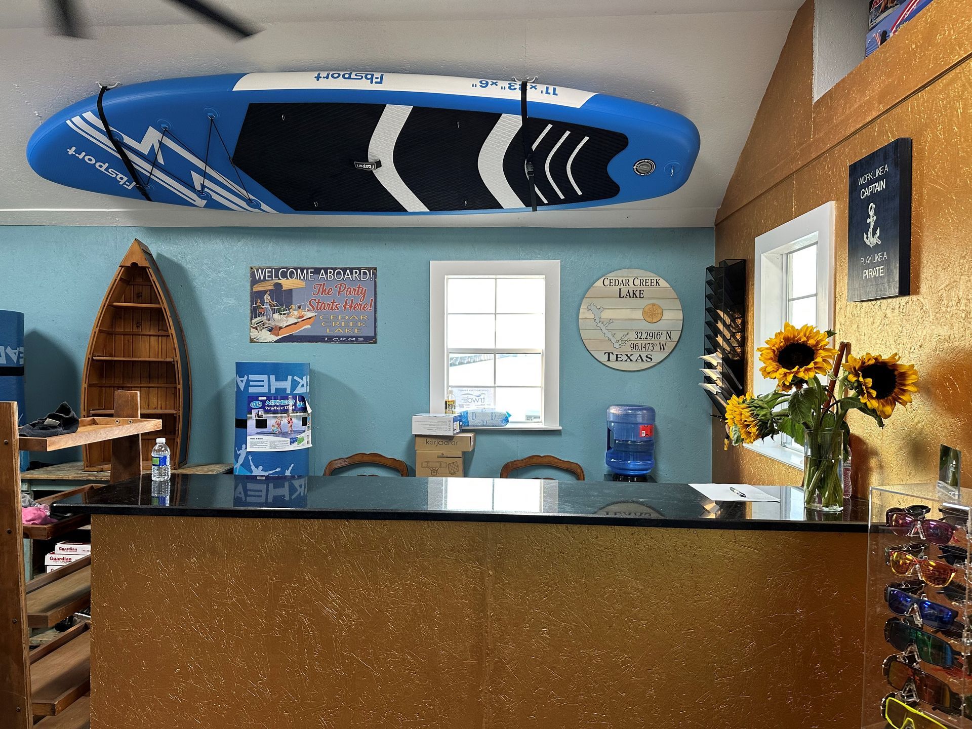 A blue paddle boardis hanging from the ceiling above a counter