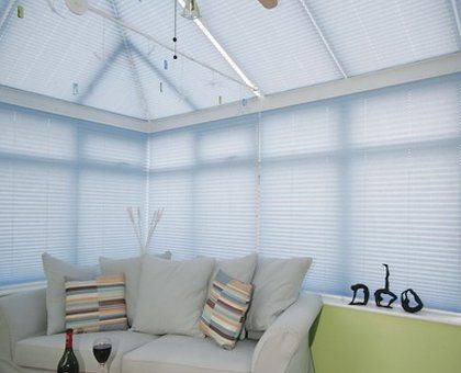 White pleated blinds in a conservatory