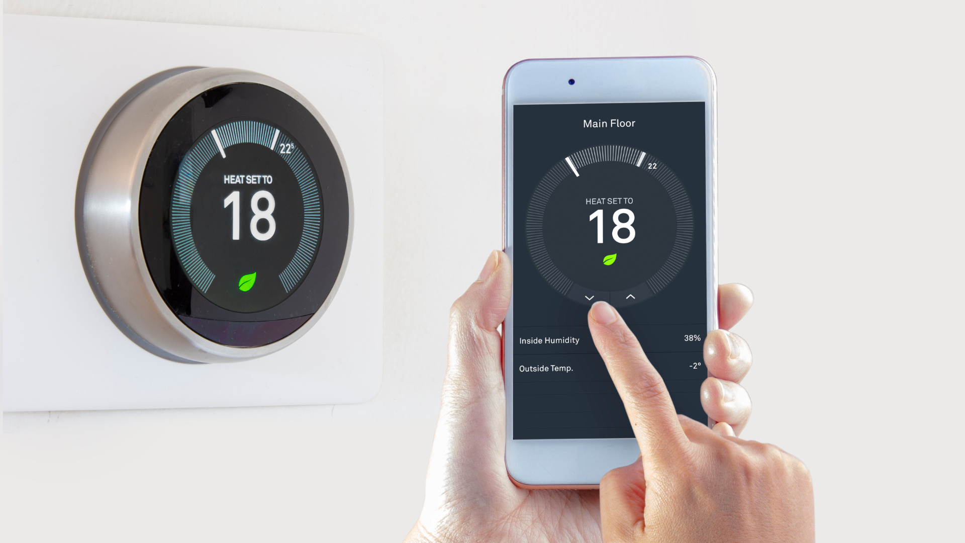 A person is using a smart phone to control a thermostat.