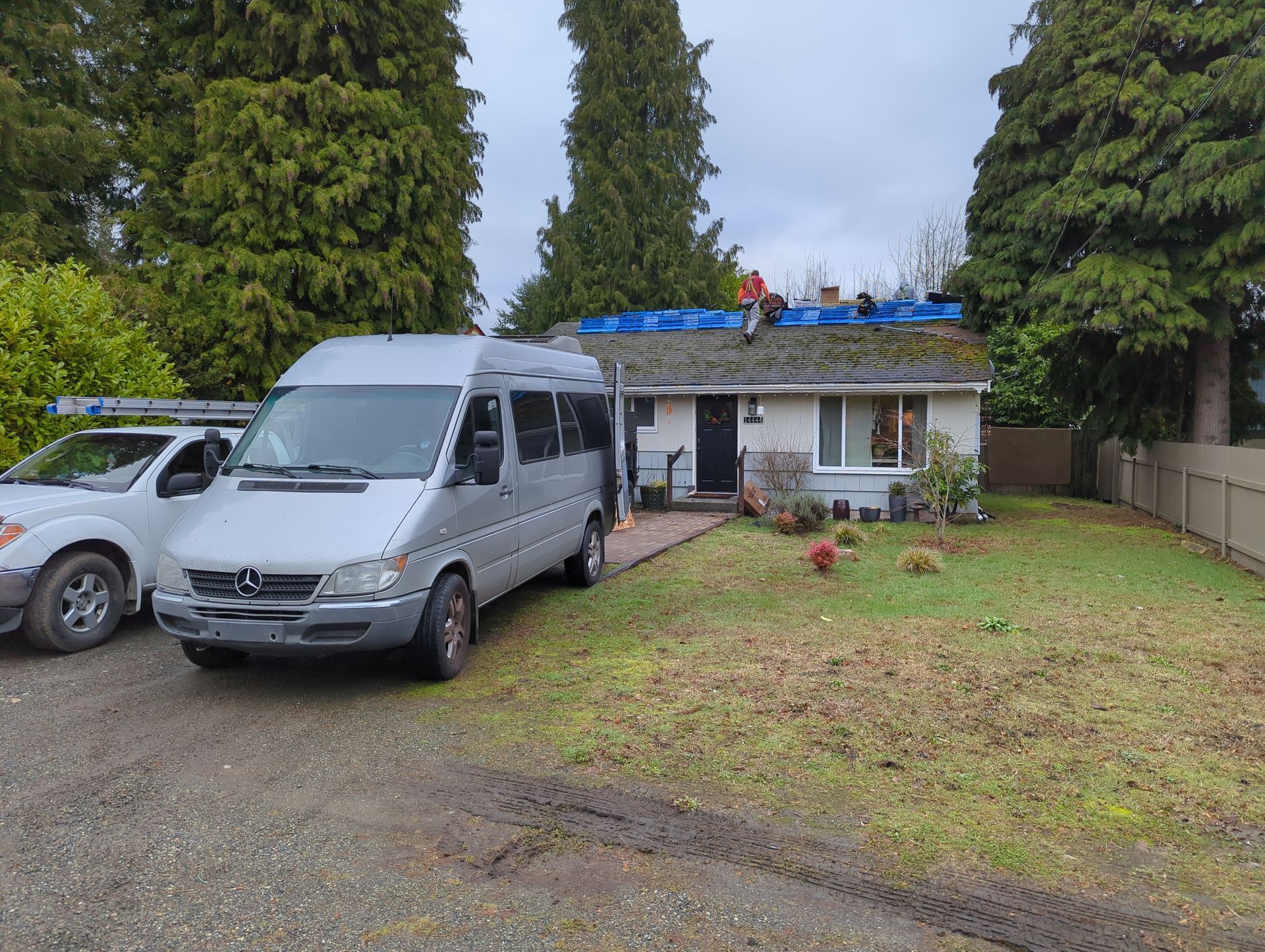 A white van is parked in front of a house.