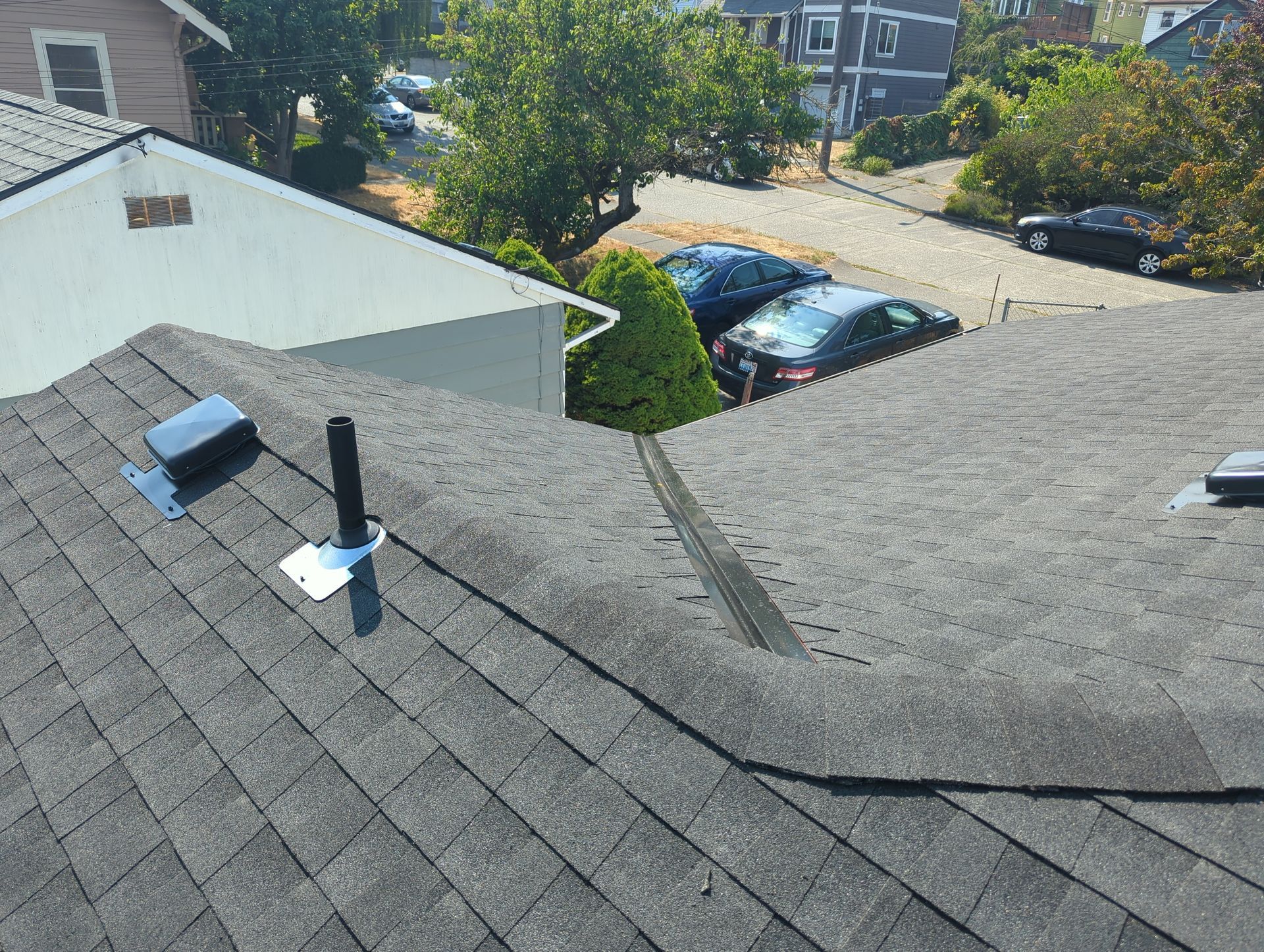A roof with a chimney and a skylight on it.
