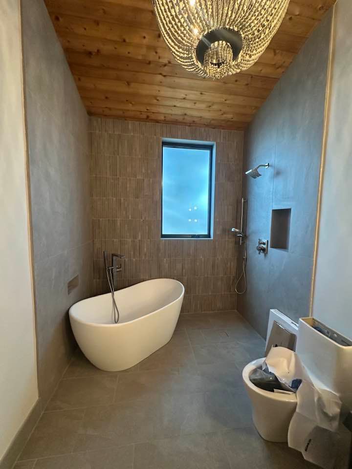 A bathroom with a bathtub , toilet and shower.