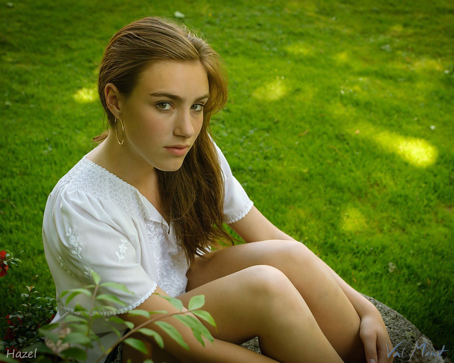 tfp shooting mädchen braune haare sitzt in shorts auf der wiese und blickt in die kamera