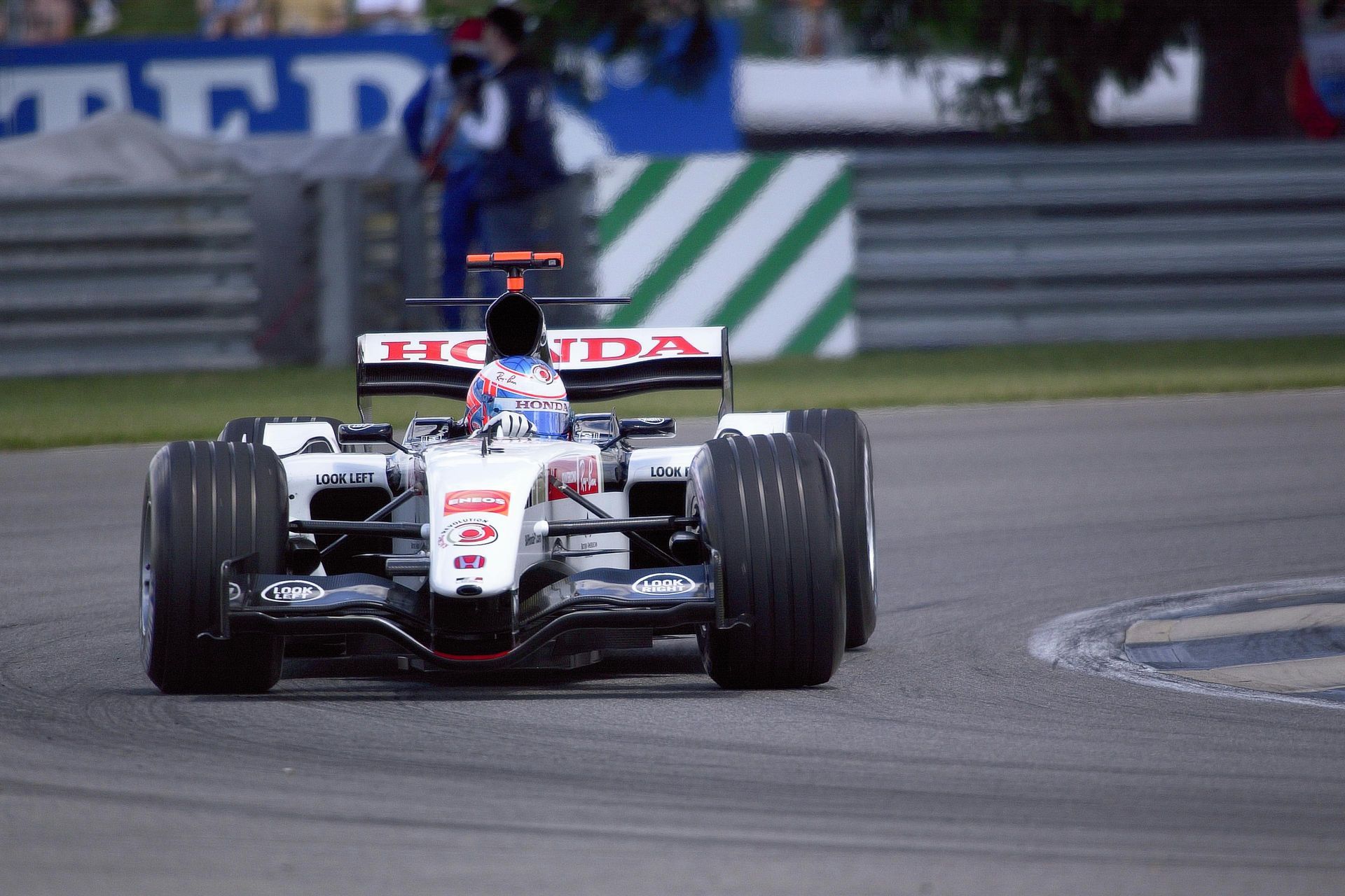 Un coche de carreras Honda blanco circula por una pista.