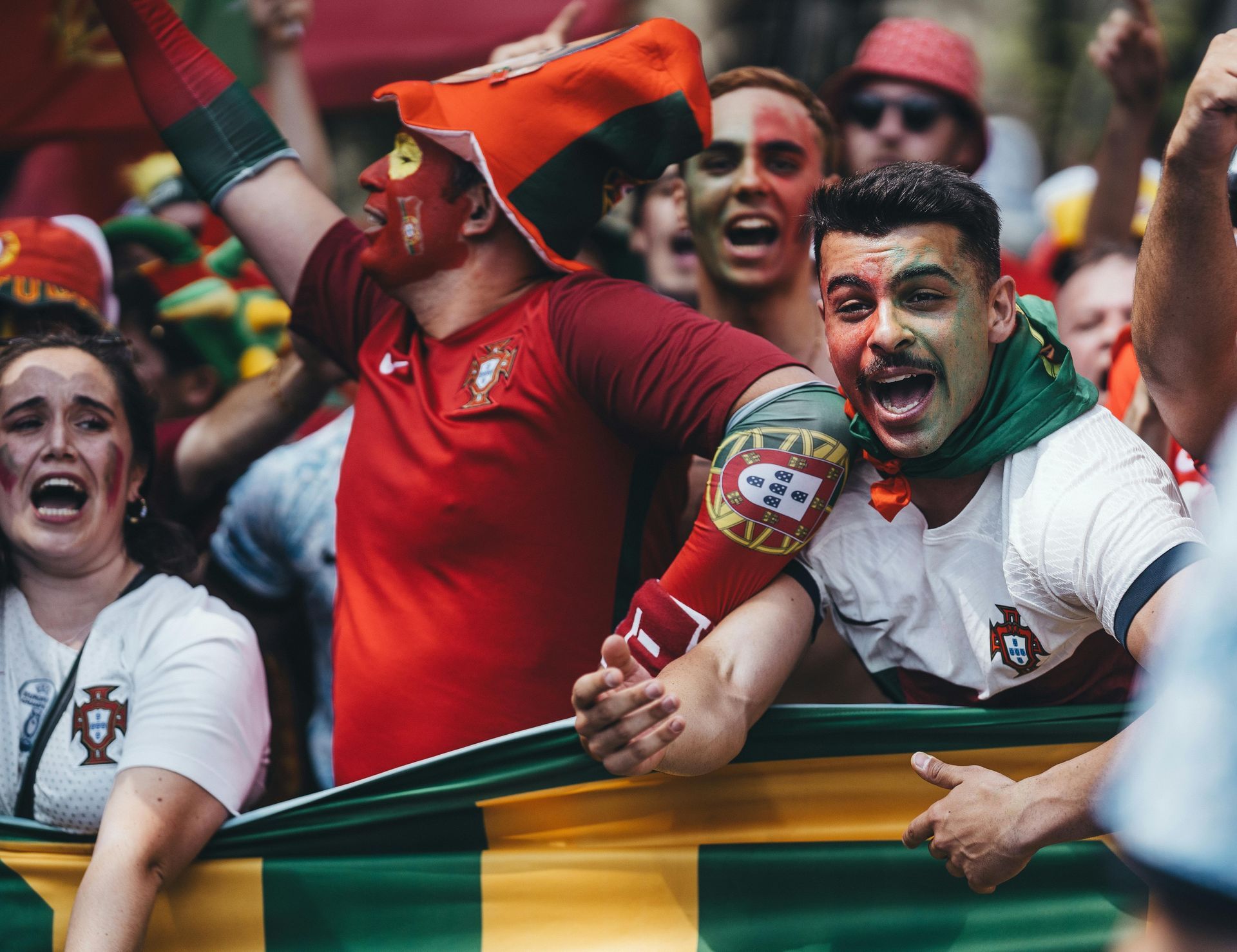 Un grupo de personas está de pie en un estadio viendo un partido de fútbol.