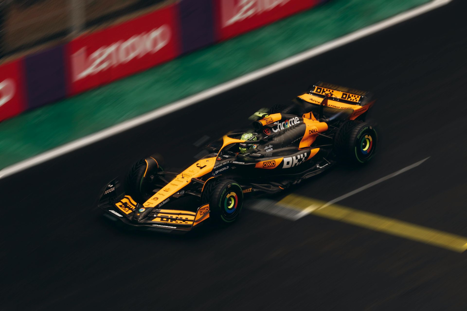Un coche de carreras negro y amarillo circula por una pista de carreras.