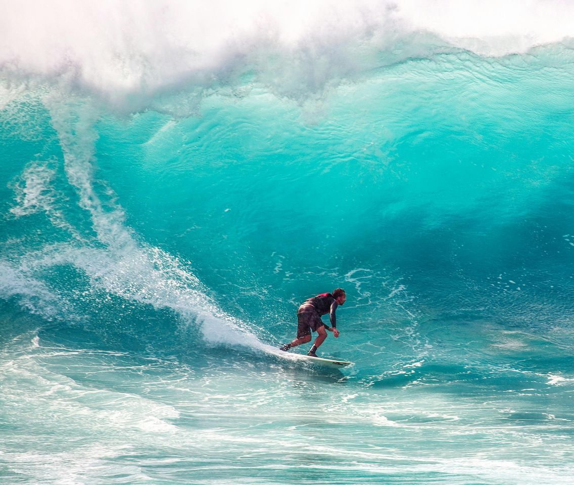 Un hombre está montando una ola en una tabla de surf en el océano.