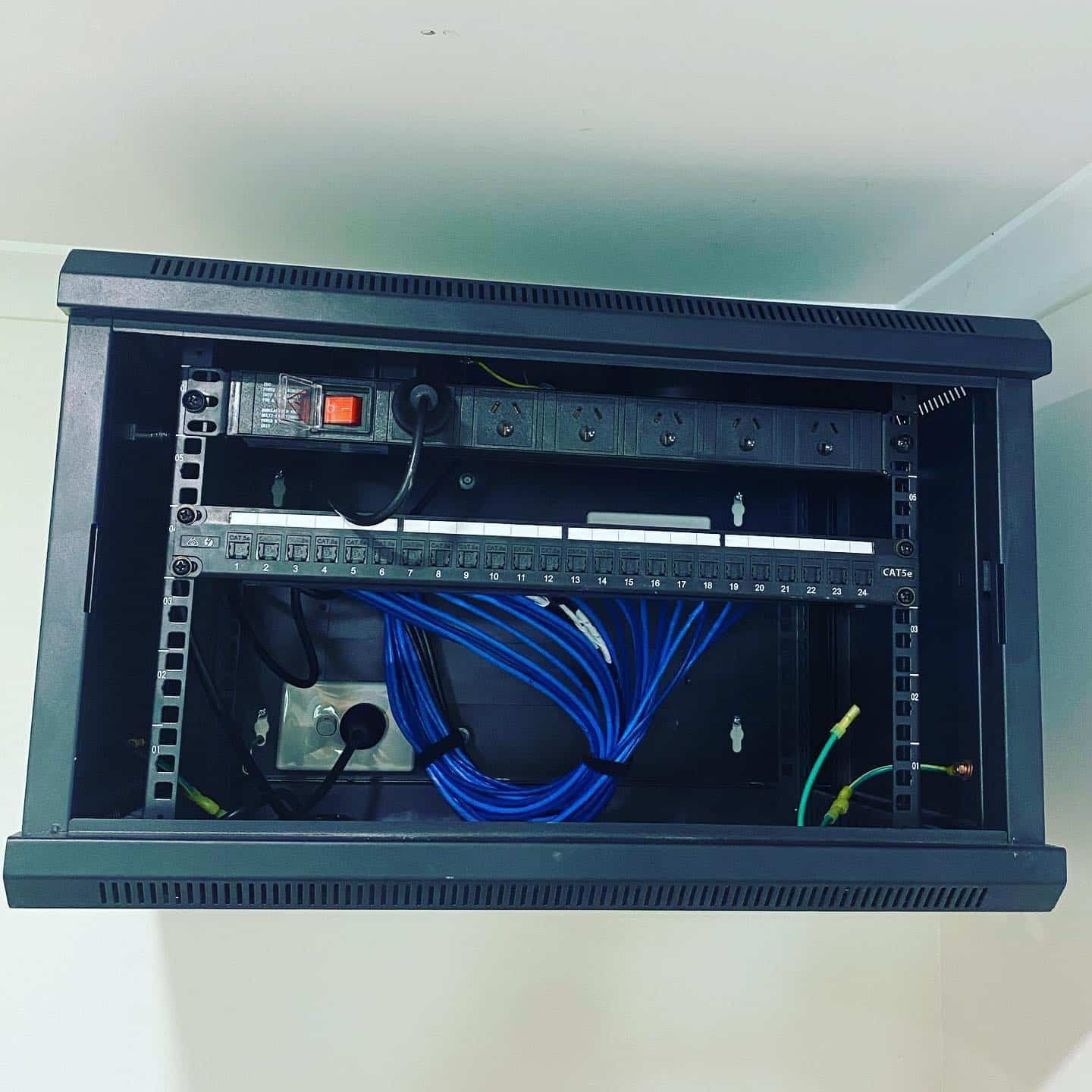 A Server Rack with A Bunch of Wires Coming out Of It — Higgins Electrical in Caboolture, QLD