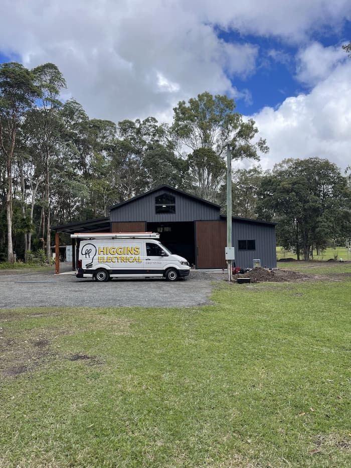 A Gray Barn With a White Van Parked in Front — Higgins Electrical in Glenview, QLD