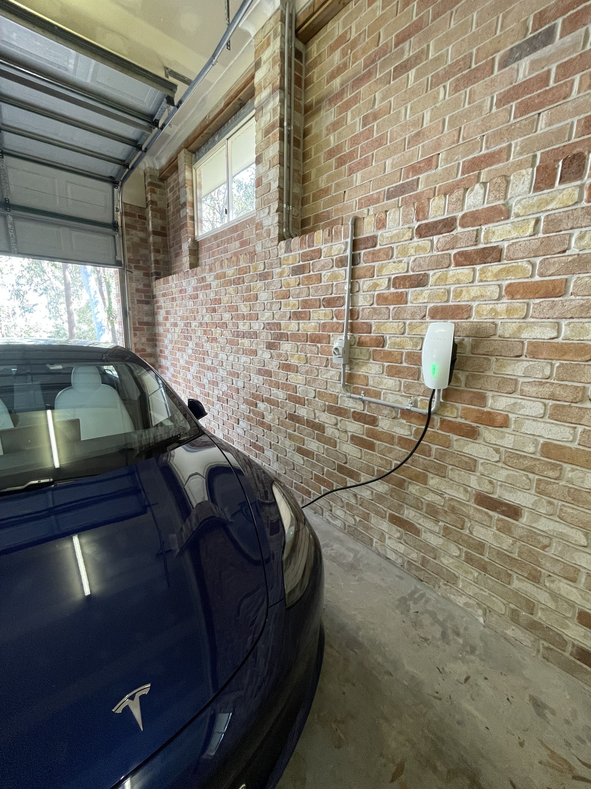 A Man in A Green Shirt Is Working on An Electrical Box — Higgins Electrical in Beerwah, QLD